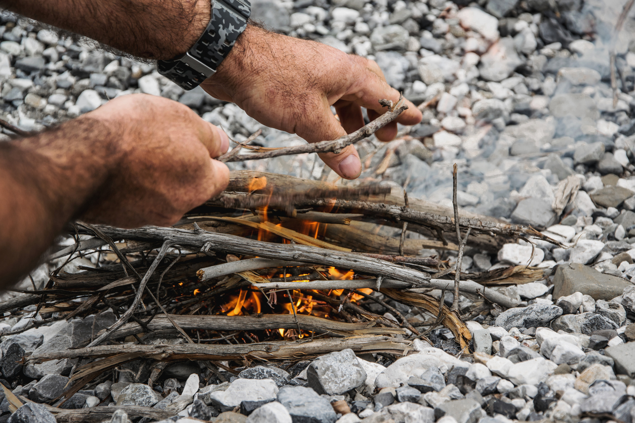 a man making a fire outdoors