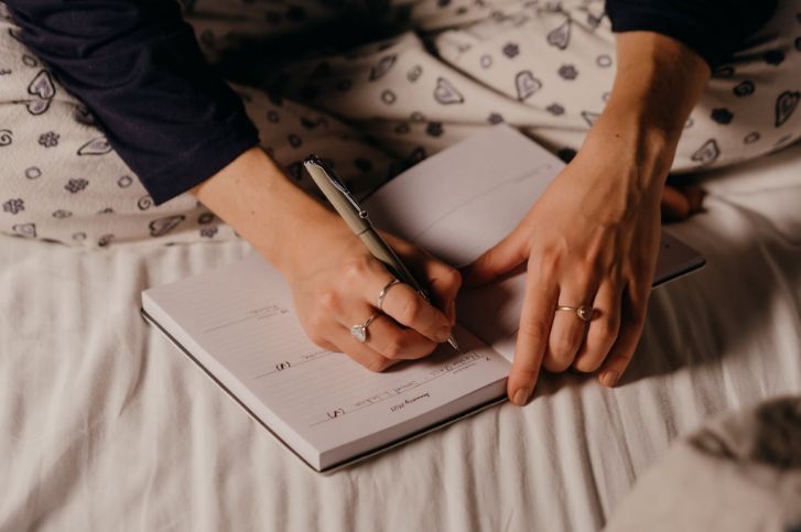 A person writing on a journal